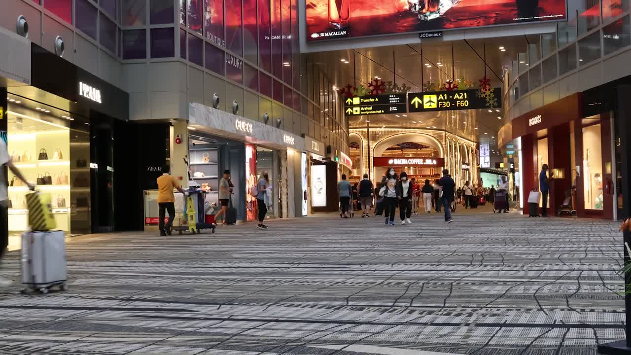 바쁜 쇼핑몰 복도를 걸어가는 쇼핑객 들