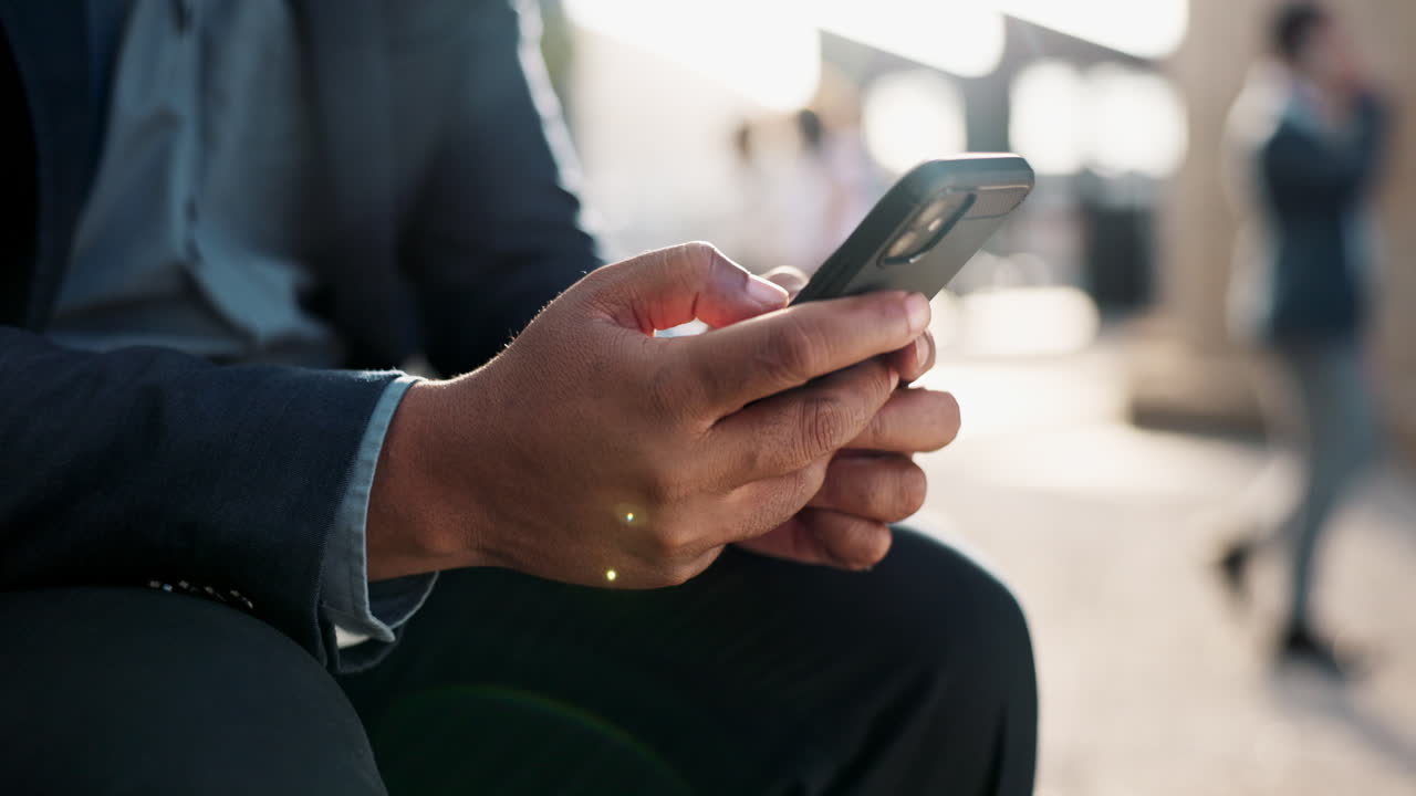 Uomo d'affari che usa lo smartphone all'aperto