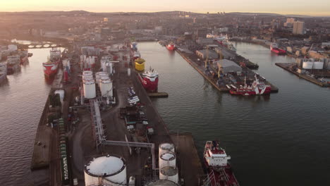 aerial view of aberdeen harbour and city at sunset - aberdeenshire, scotland, uk. flight over harbour with city in background.