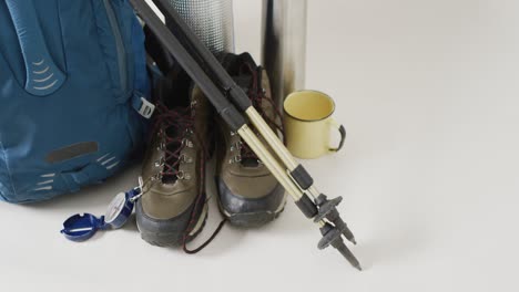 camping equipment with rucksack,walking poles, boots and copy space on white background