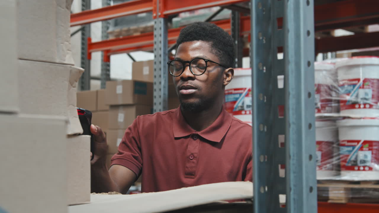 Male Warehouse Manager Checking Boxes with Barcode Scanner