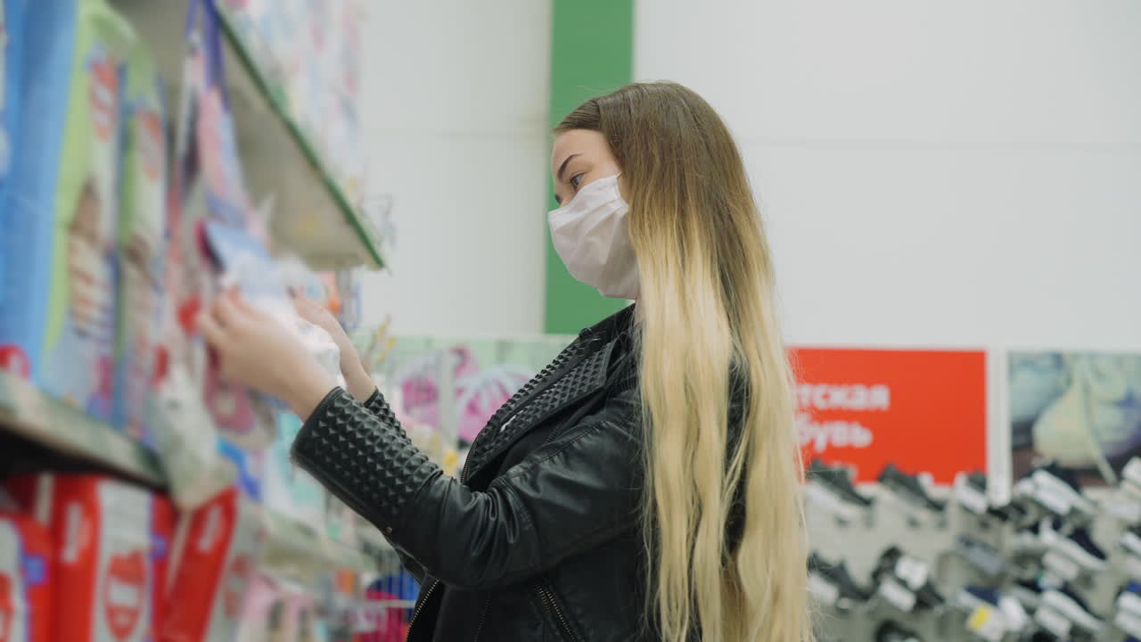 마스크를 착용 한 상점 에서 아기 제품 을 구매 하는 여자