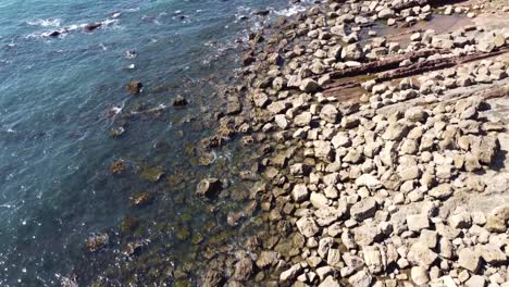 rocky shoreline with calm water coming into shore in são martinho do porto, portugal