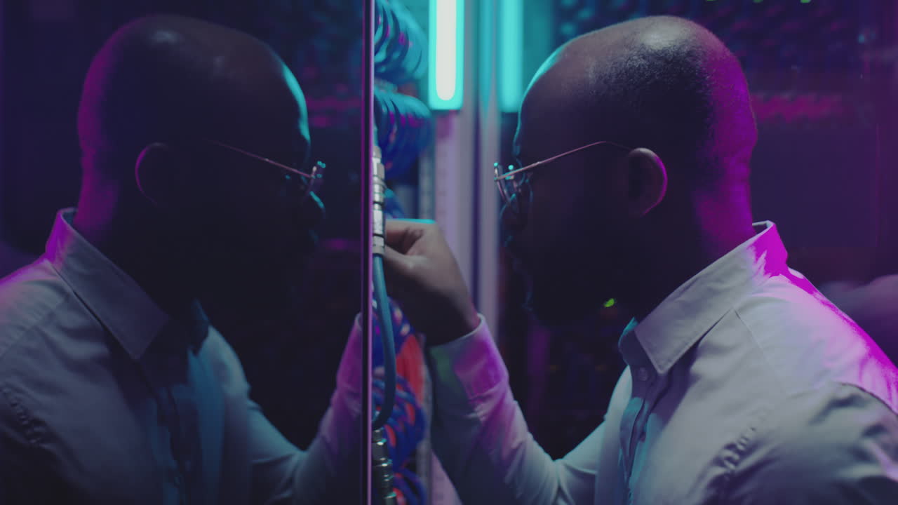 IT Professional Working in a Data Center with Neon Lights