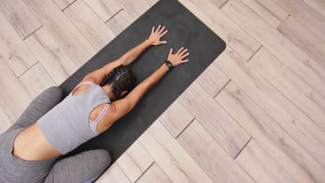 practicing yoga, woman stretching on yoga mat in child's pose, copy space