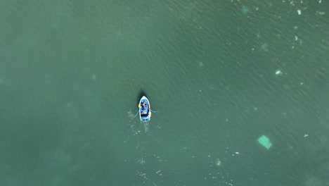 small boat drifting on polluted shallow water