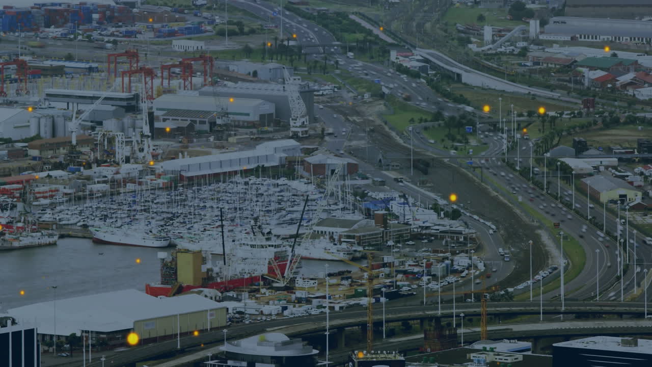 Boats in busy harbor with industrial buildings, yellow lights creating animation