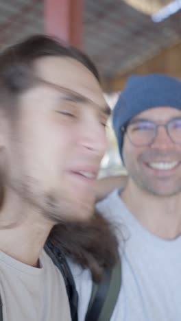 two men, one with long hair and beard, smiling and talking