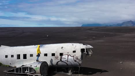 persona caminando sobre un avión naufragado en islandia