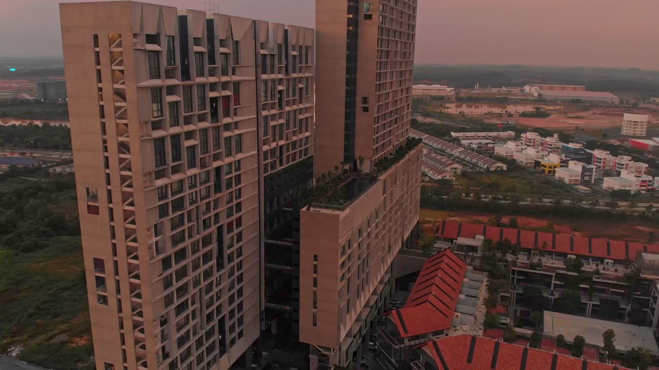 Luftfoto af moderne lejligheder og swimmingpool, der lyser op ved solopgang i Cyberjaya, Malaysia.