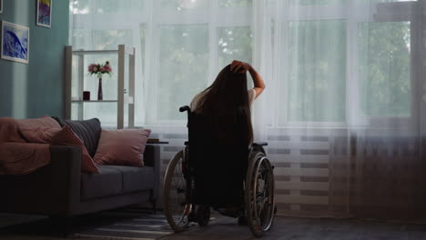 Mujer-Discapacitada-Toca-El-Cabello-Sentada-En-Silla-De-Ruedas-Junto-A-La-Ventana