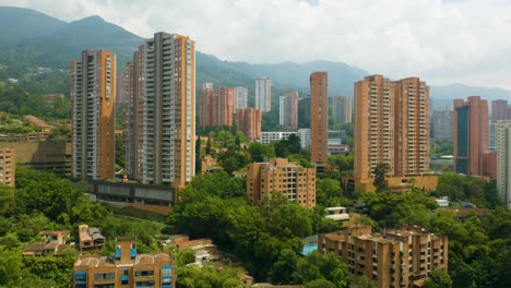 Drone-Elevates-to-Reveal-El-Poblado-Neighborhood-on-Cloudy-Day-in-Medellin,-Colombia