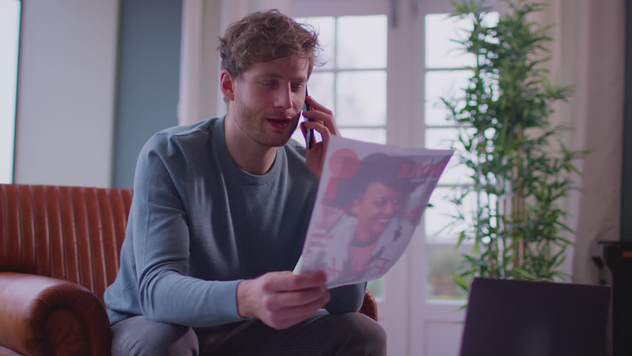 Man Working From Home In Creative Design Or Marketing Industry On Phone Approving Artwork Design