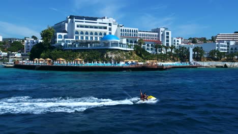 A-couple-crosses-the-sea-in-front-of-the-hotel-by-jetski