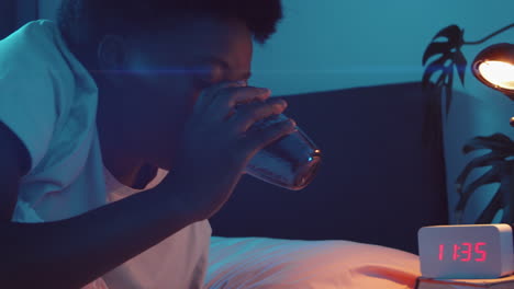 african american woman drinking water before sleeping in night