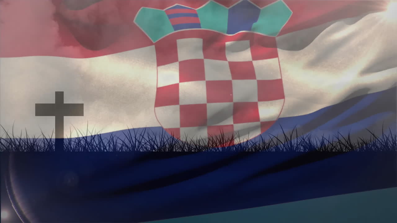 Waving Croatian flag with cross silhouette in foreground, grass swaying gently