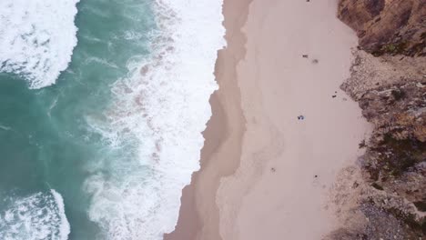 Antenne-Von-Oben-Nach-Unten-Vorbeifliegen-Der-Wilden-Wellen-Am-Praia-Da-Ursa,-Portugal