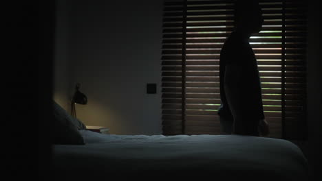 man looking out the window at night
