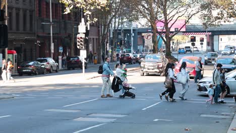 pedestrians crossing a busy street in melbourne