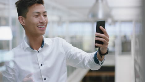 Joven-Empresario-Asiático-Teniendo-Video-Chat-Usando-Un-Teléfono-Inteligente-Charlando-Con-Un-Vendedor-De-Teléfonos-Móviles-Disfrutando-De-Una-Conversación-Con-Un-Cliente-En-El-Lugar-De-Trabajo-De-La-Oficina-Corporativa-4k