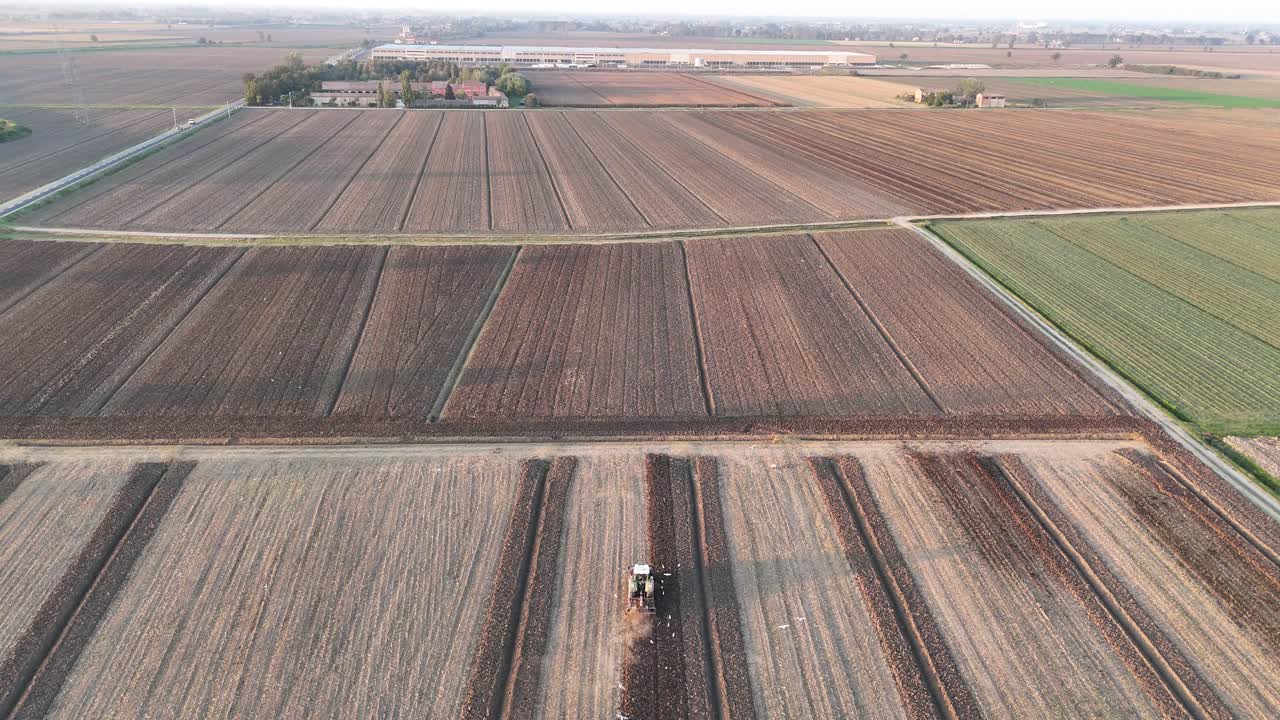 Aerial drone view of mixed agricultural plots in the Po Valley, showing mechanized fieldwork and crop rotation