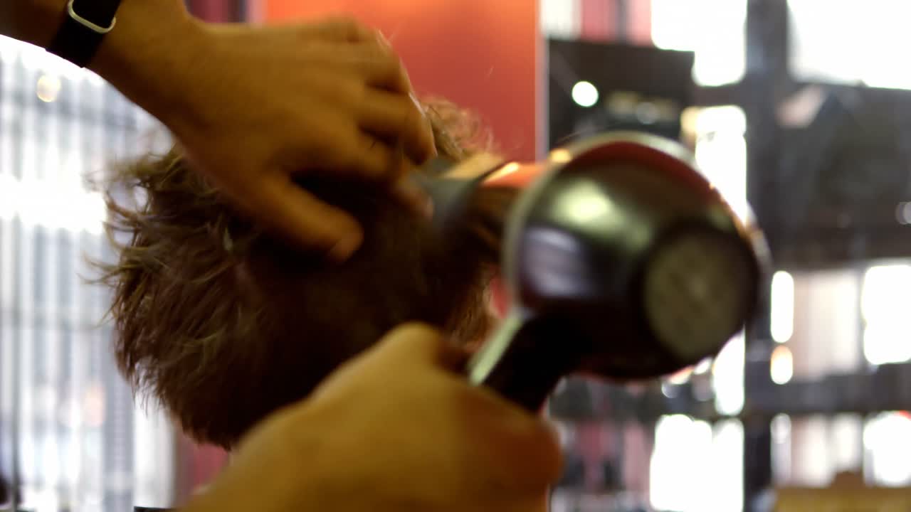 hombre usando secador de cabello en el cabello del cliente 4k