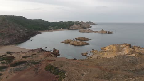 Drone-fly-low-above-coastal-blue-bay-still-water-in-islet-humid-sandy-landscape