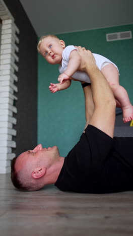 little newborn baby with father having fun. cute child with happy dad. vertical video.