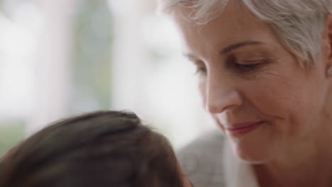 abuela feliz besando suavemente a la niña en la frente mostrando amor por la nieta abuela orgullosa compartiendo afecto por el nieto en casa