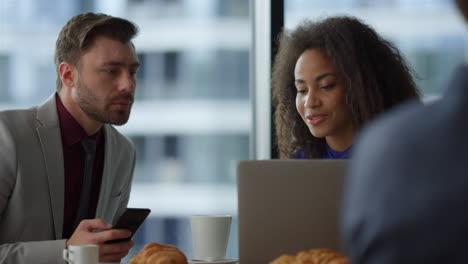 multiethnic couple business people sitting using phone laptop in cafe office.