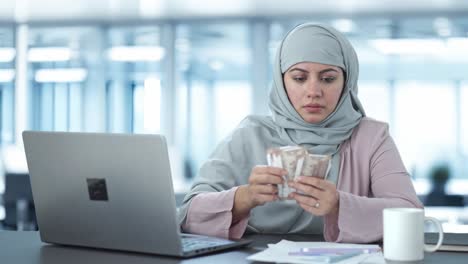 serious muslim businesswoman counting money