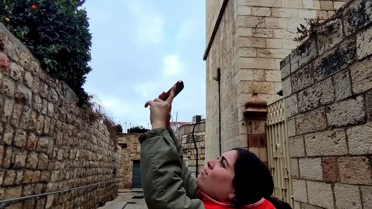 Female Tourist Pointing Up at an Ancient Stone Wall in Jerusalem
