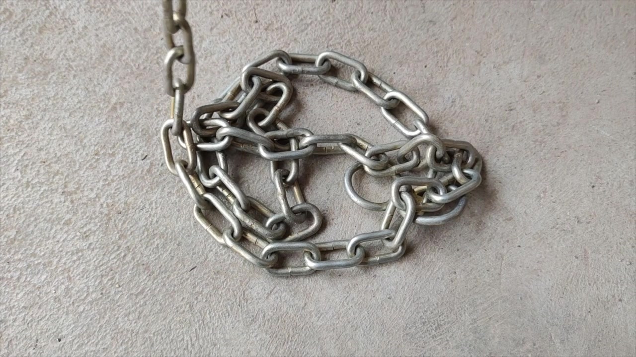 Cadena de metal amontonándose sobre una superficie de hormigón