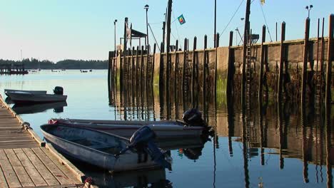 A-lobster-village-in-Stonington-Maine-is-near-a-pier-made-of-wood-reflecting-into-water-