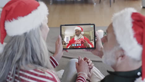 Feliz-Pareja-De-Ancianos-Diversos-Y-Amigo-Masculino-Teniendo-Videollamada-De-Tableta-Navideña,-Cámara-Lenta