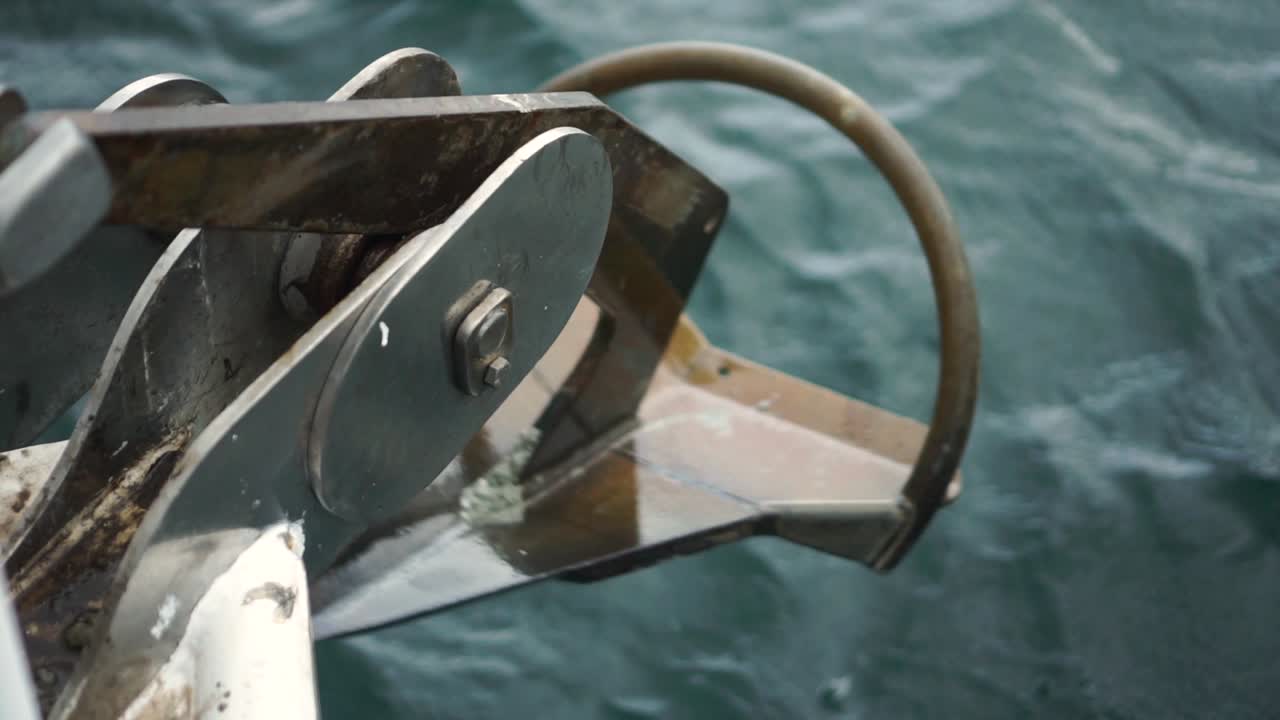 cámara lenta - ancla de barco levantada con el océano al fondo - primer plano