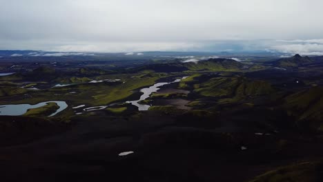 aerial panoramic view of icelandic highlands, dark hills and mountains, rivers and lakes, on a moody day