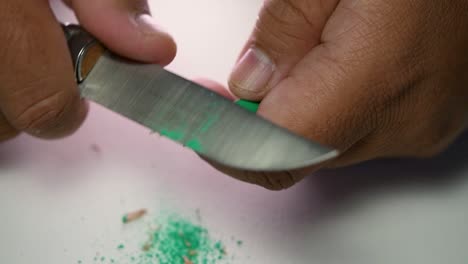 Footage-of-hands-slowly-sharpening-a-pencil-and-some-coloured-pencils-with-a-sharp-knife