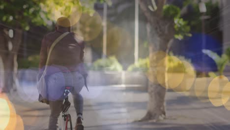 animation of glowing lights over african american businessman cycling in city