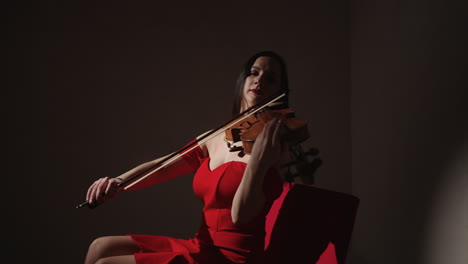 woman playing violin in red dress