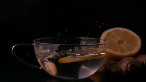 lemon slices falling into glass cup of water