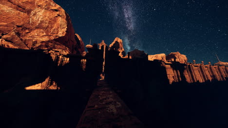 a stone castle with an entrance gate under a night sky with stars and the milky way