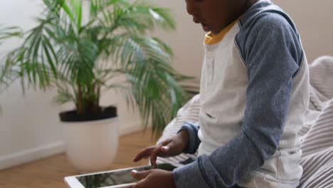 Boy-using-tablet-computer-at-home