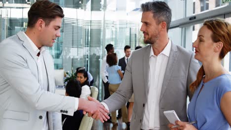 Business-people-shaking-hands-in-office