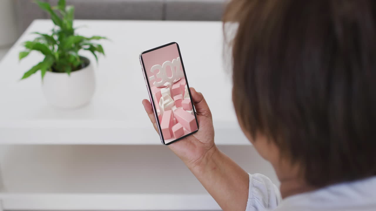 mujer biracial usando teléfono inteligente en casa compras en línea durante la venta, cámara lenta