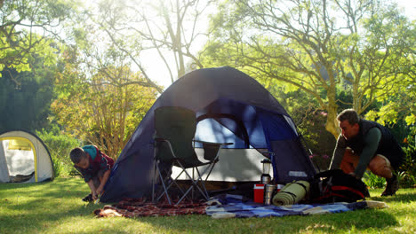 father and son setting up a tent