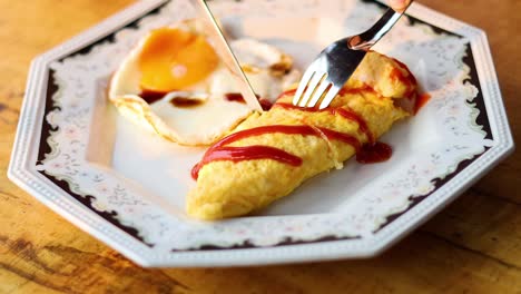 fork and knife cutting an omelet