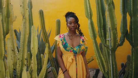 woman in a yellow floral dress among cacti