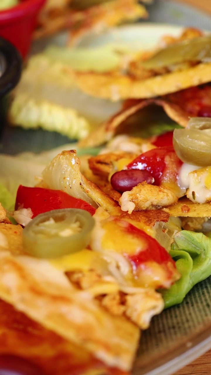 Primo piano di deliziosi nachos di pollo con jalapeños e formaggio fuso
