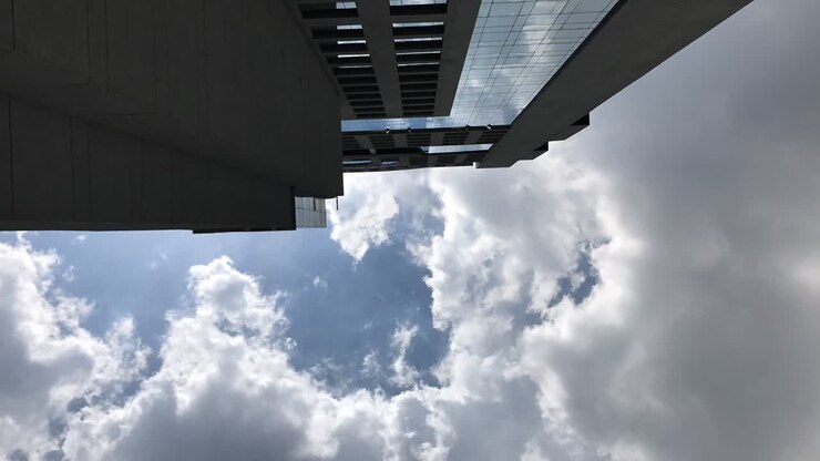timelapse de nuvens passando por um arranha-céu, olhando para a lateral de um arranha-céu